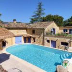 Piscine partag&eacute;e et terrasse privative du g&icirc;te &agrave; l'arri&egrave;re plan